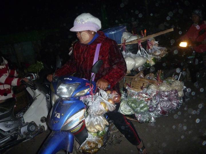 At the morning market about 5:30am a lady loads up with wears to sell in outlying areas.